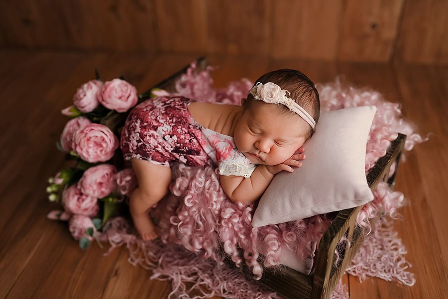 Süßes Baby Mädchen schläft auf dem Bett während entspanntem Babyshooting